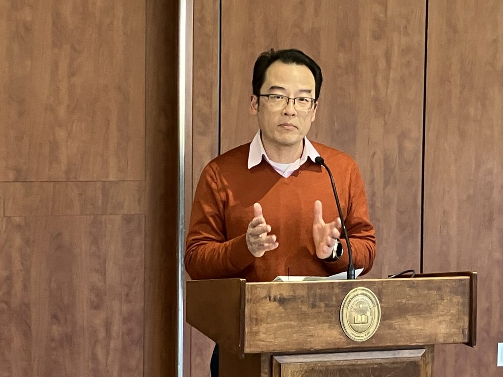 Jimmy Chen speaking at a lectern.